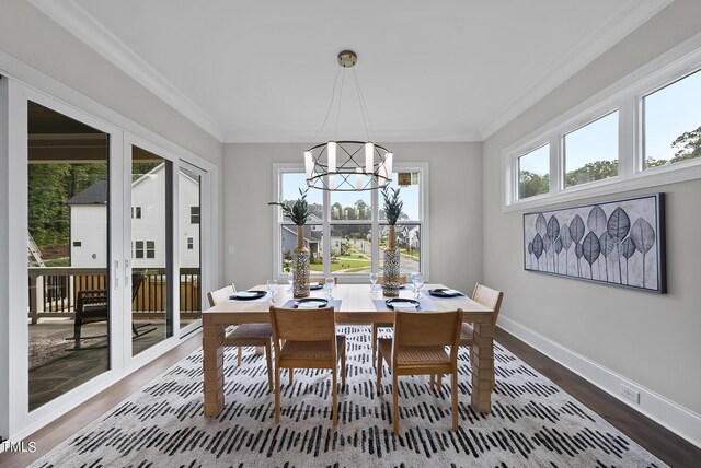 dining area featuring wood-type flooring, a chandelier, and crown molding