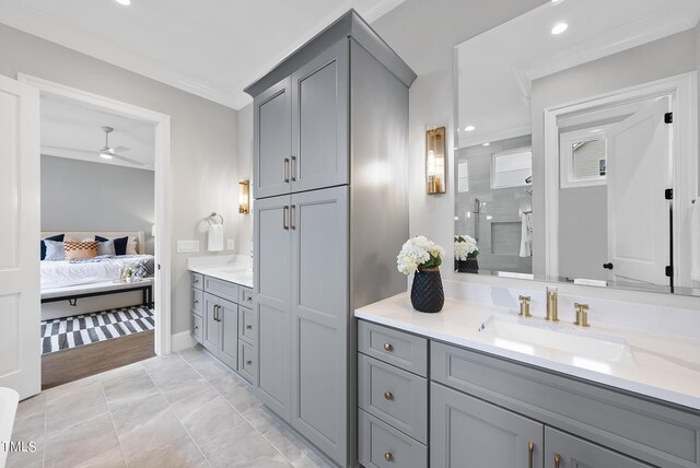 bathroom featuring walk in shower, vanity, ornamental molding, and ceiling fan