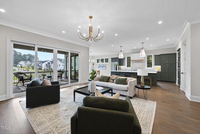 living room with an inviting chandelier, hardwood / wood-style floors, and crown molding