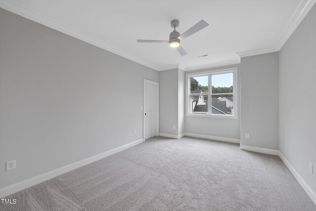 carpeted empty room with crown molding and ceiling fan