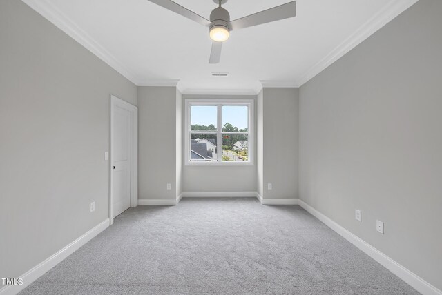 carpeted spare room featuring ceiling fan and crown molding