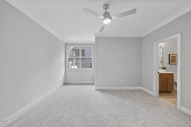 carpeted spare room featuring crown molding and ceiling fan