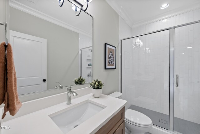 bathroom with ornamental molding, walk in shower, vanity, and toilet