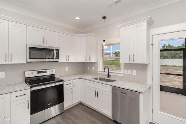 kitchen with appliances with stainless steel finishes, white cabinets, visible vents, and a sink