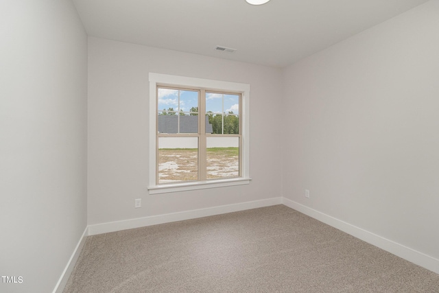 spare room featuring carpet flooring, visible vents, and baseboards