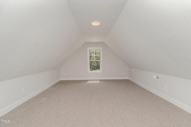 additional living space featuring carpet, vaulted ceiling, and baseboards