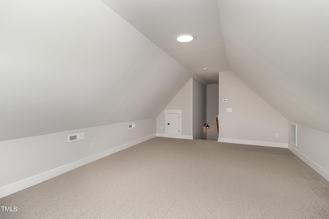 additional living space with lofted ceiling, carpet flooring, visible vents, and baseboards