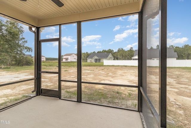 unfurnished sunroom with ceiling fan