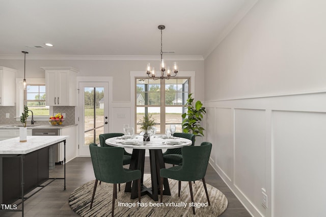 dining space featuring crown molding, dark wood-style flooring, a notable chandelier, and a decorative wall