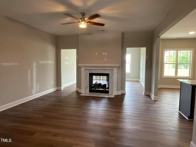 unfurnished living room with dark hardwood / wood-style floors, a fireplace, and ceiling fan