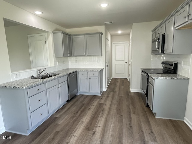 kitchen featuring sink, light stone countertops, stainless steel appliances, and tasteful backsplash