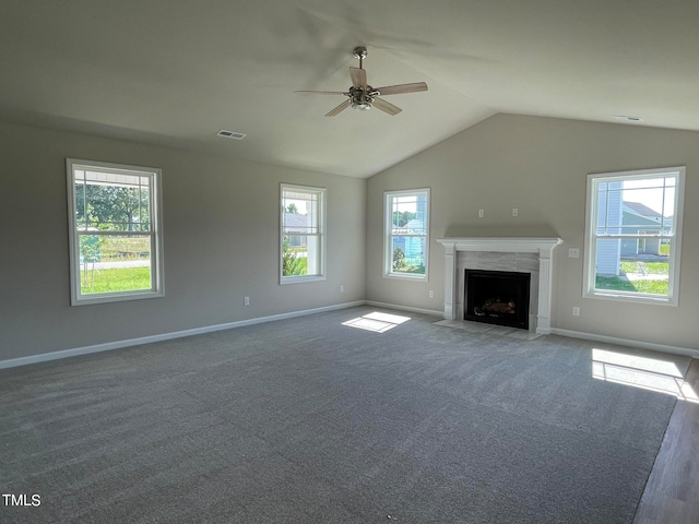 unfurnished living room with dark carpet, ceiling fan, a high end fireplace, and lofted ceiling