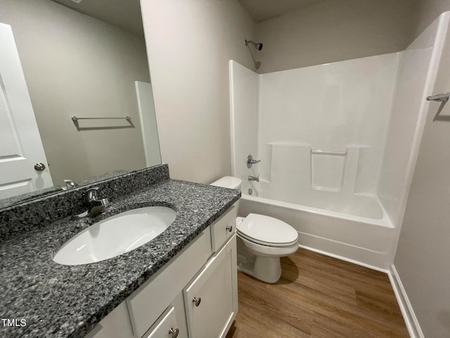 full bathroom featuring  shower combination, hardwood / wood-style flooring, toilet, and vanity