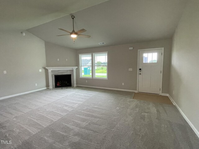 unfurnished living room with lofted ceiling, light colored carpet, and ceiling fan