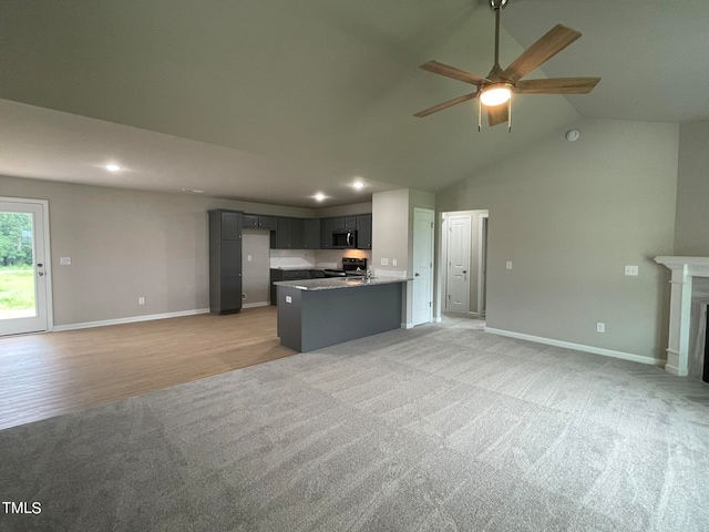 unfurnished living room with high vaulted ceiling, light carpet, and ceiling fan