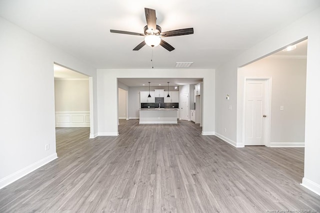 unfurnished living room with ceiling fan and hardwood / wood-style floors