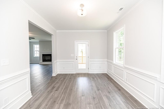 interior space with a healthy amount of sunlight, hardwood / wood-style flooring, and crown molding