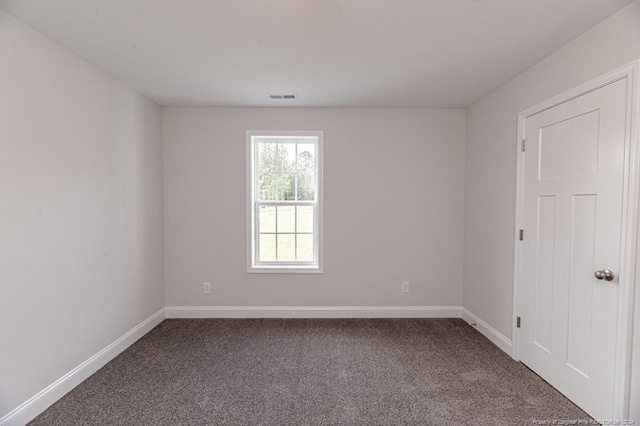 unfurnished room with dark carpet