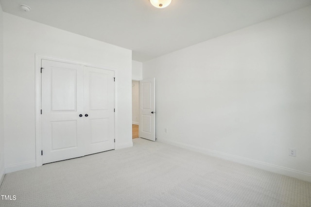 unfurnished bedroom with a closet and light carpet