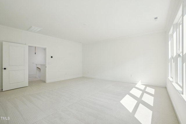 empty room featuring light colored carpet and crown molding