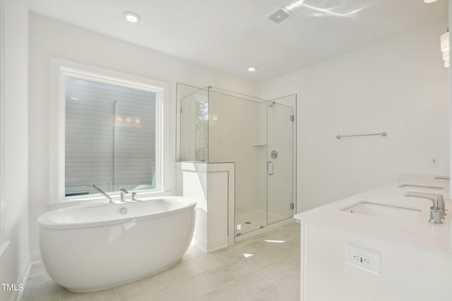 bathroom with tile patterned flooring, double sink vanity, and independent shower and bath