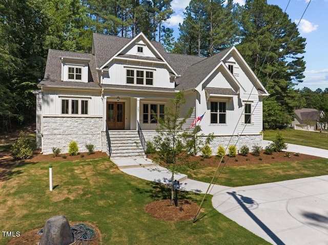 craftsman-style home featuring a porch, french doors, and a front lawn