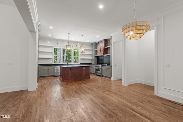 kitchen featuring gray cabinetry, a center island, stainless steel appliances, backsplash, and decorative light fixtures