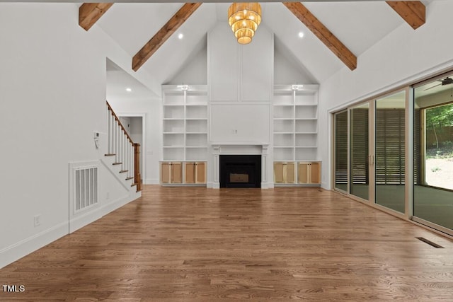 unfurnished living room with beam ceiling, high vaulted ceiling, and wood-type flooring