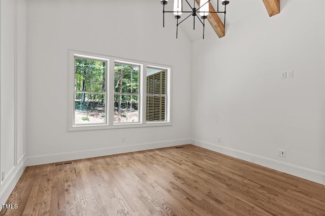 spare room with beamed ceiling, light hardwood / wood-style flooring, high vaulted ceiling, and a chandelier