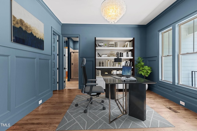 office area featuring a chandelier, built in shelves, dark hardwood / wood-style flooring, and crown molding