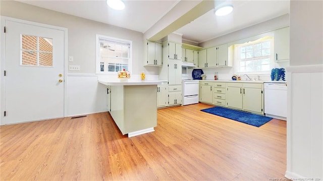 kitchen featuring white appliances, light hardwood / wood-style floors, sink, and kitchen peninsula