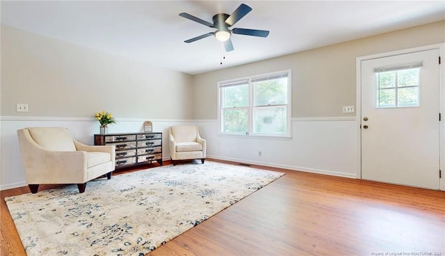 sitting room featuring hardwood / wood-style floors, ceiling fan, and a healthy amount of sunlight