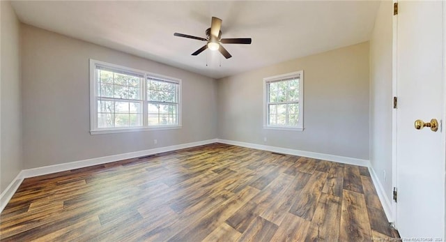 spare room with a wealth of natural light, dark hardwood / wood-style flooring, and ceiling fan