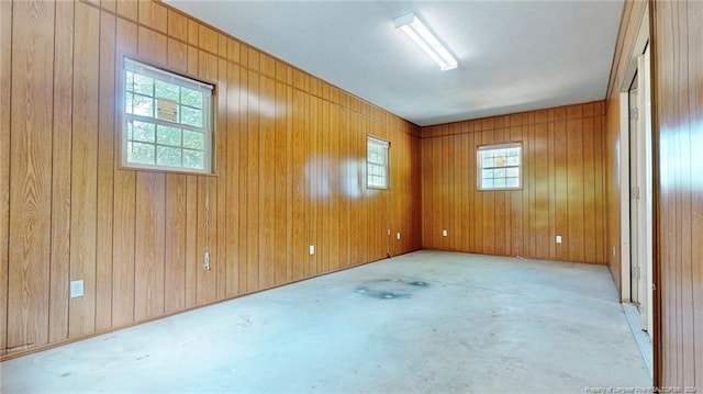 empty room with a wealth of natural light and wood walls