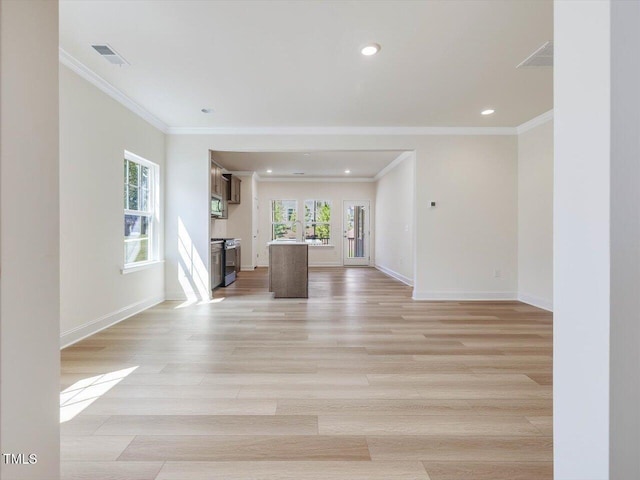 unfurnished living room with ornamental molding, light wood finished floors, visible vents, and baseboards