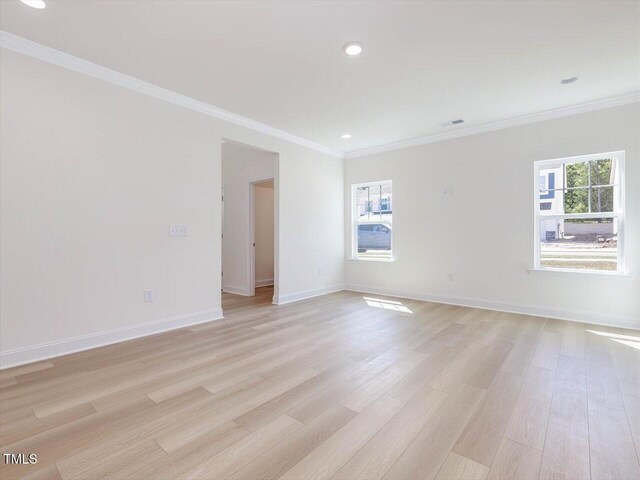 spare room with light wood-style flooring, baseboards, and crown molding