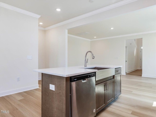 kitchen with a sink, light wood finished floors, light countertops, and dishwasher