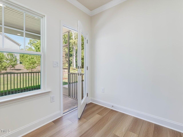 entryway featuring baseboards, crown molding, and light wood finished floors