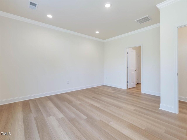 spare room with visible vents, crown molding, and light wood finished floors