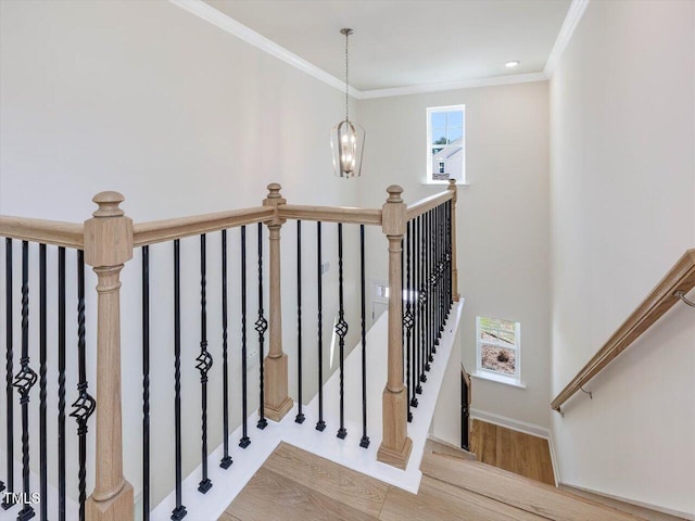 stairs featuring crown molding, baseboards, and wood finished floors