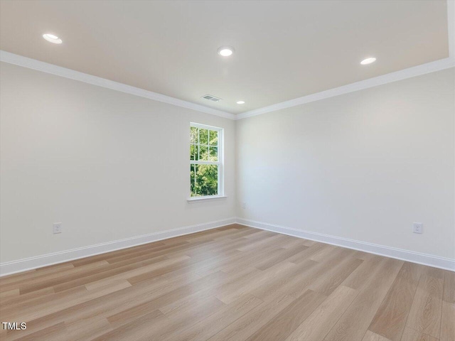 spare room featuring baseboards, crown molding, and light wood finished floors