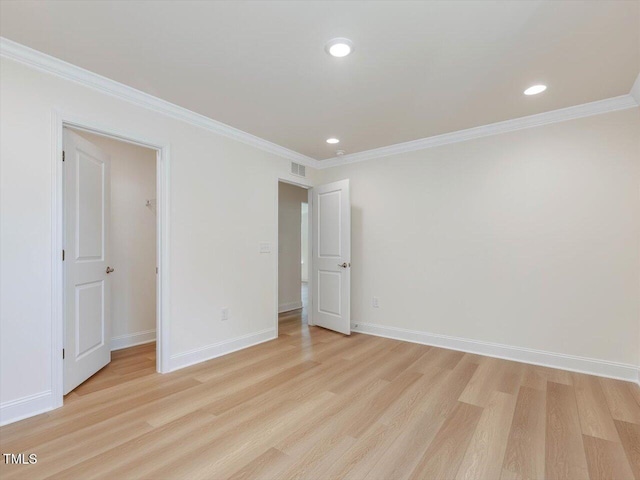 unfurnished room featuring baseboards, crown molding, visible vents, and light wood-style floors