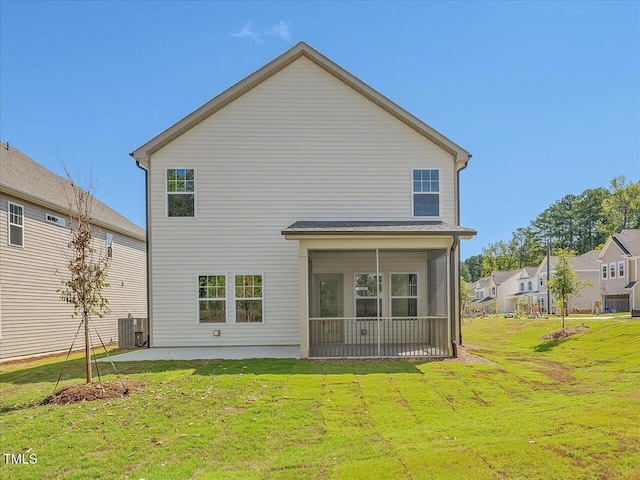 back of property with a yard, a sunroom, and central air condition unit