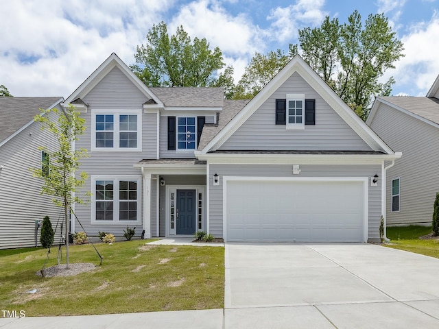 view of front of home with an attached garage, driveway, roof with shingles, and a front yard