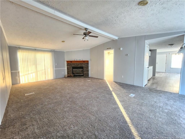 unfurnished living room featuring a fireplace, a textured ceiling, beam ceiling, light carpet, and ceiling fan