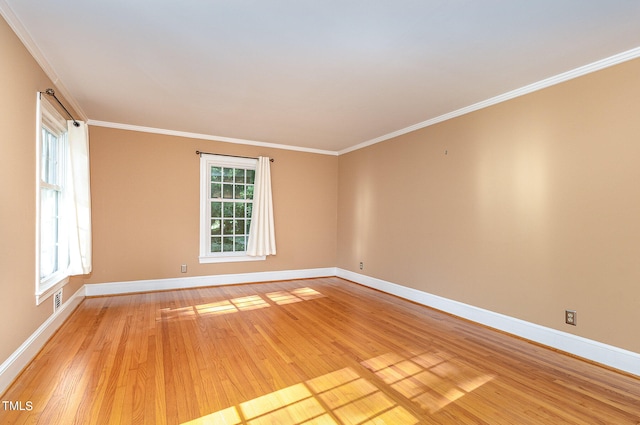 spare room with light hardwood / wood-style floors and crown molding