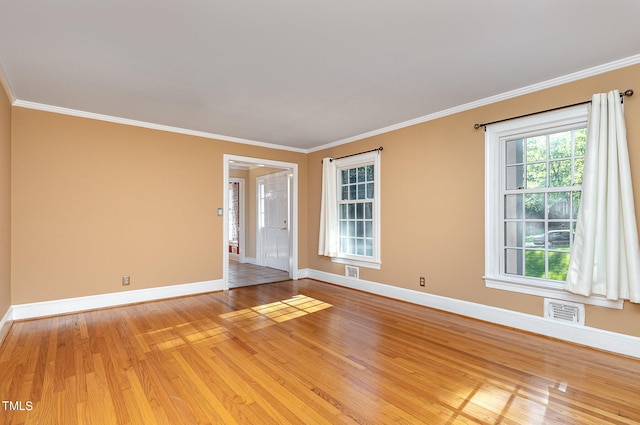 unfurnished room featuring ornamental molding and light hardwood / wood-style flooring