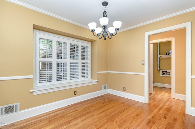 unfurnished dining area featuring light hardwood / wood-style flooring, a chandelier, and ornamental molding