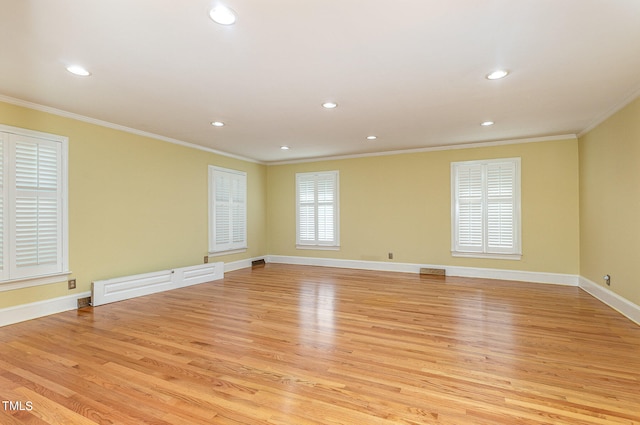 empty room featuring ornamental molding and light hardwood / wood-style flooring