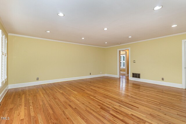 unfurnished room with light wood-type flooring and ornamental molding